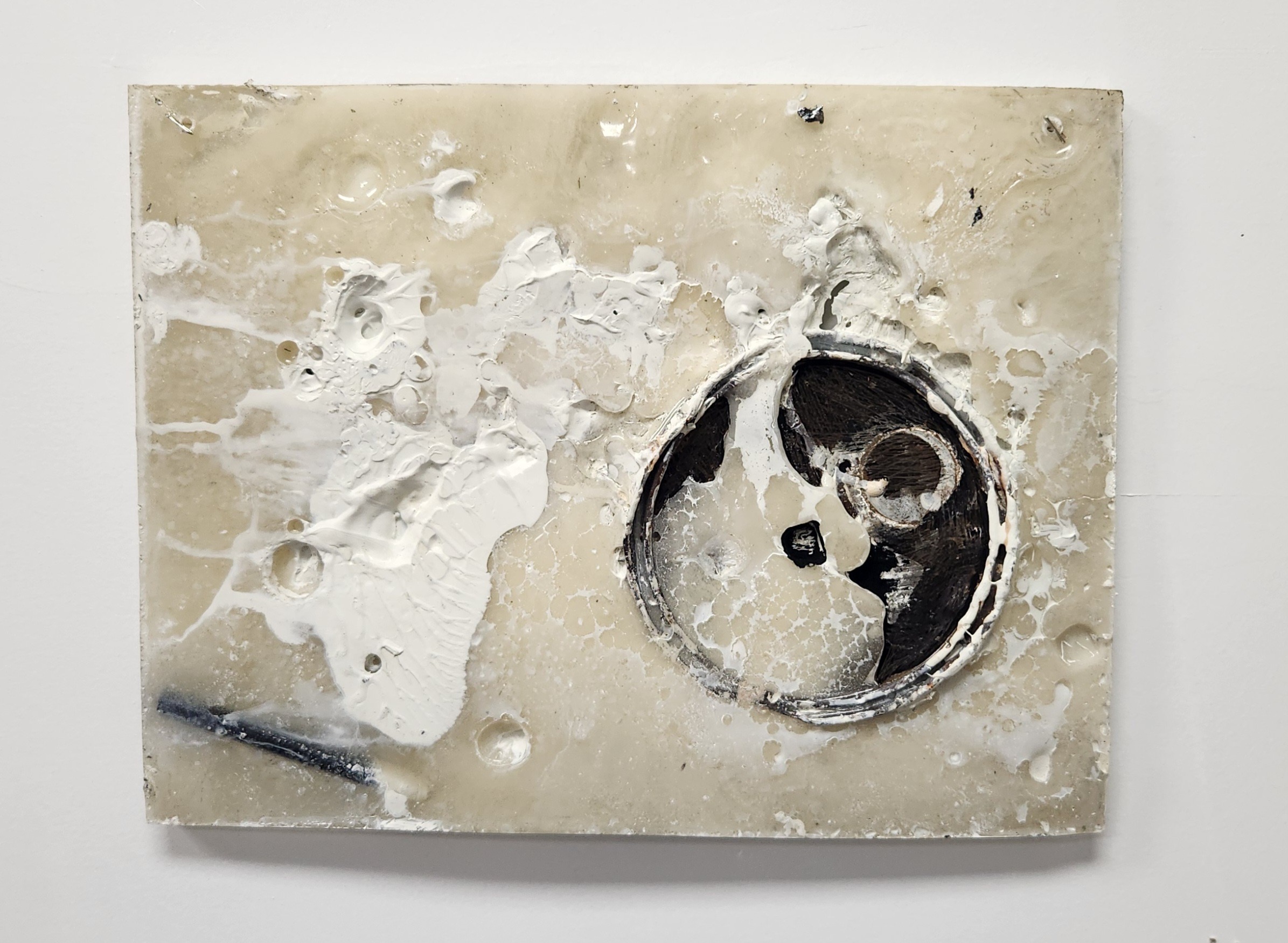 Damaged wall with holes and a circular black and white object, possibly a clock or gauge, embedded in the wall.